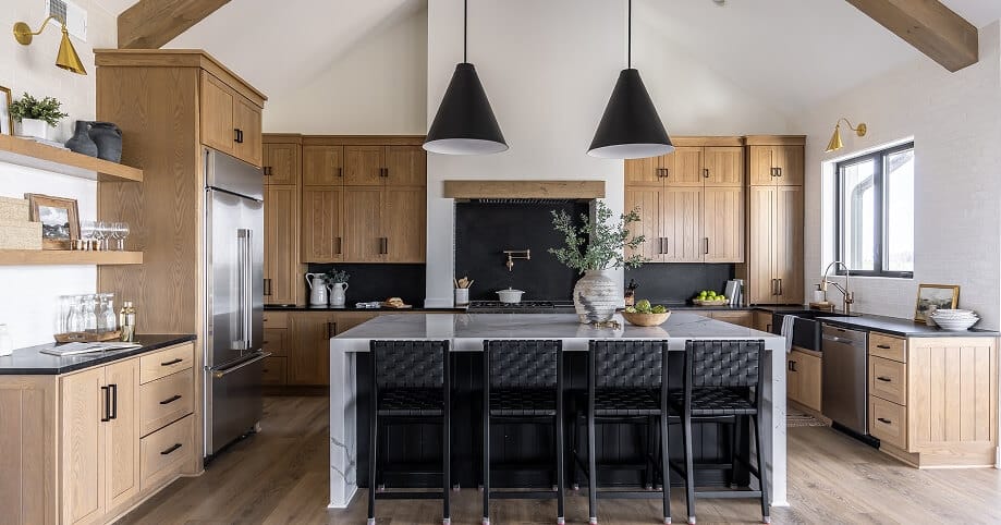 White oak shaker kitchen cabinets with black hardware, marble island, and vaulted ceiling